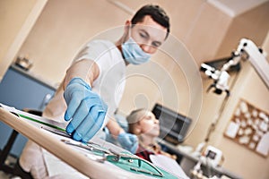 Cavities donÃ¢â¬â¢t scare us! Teen at the dental office. Dentist treats teeth, girl lying in the dental chair